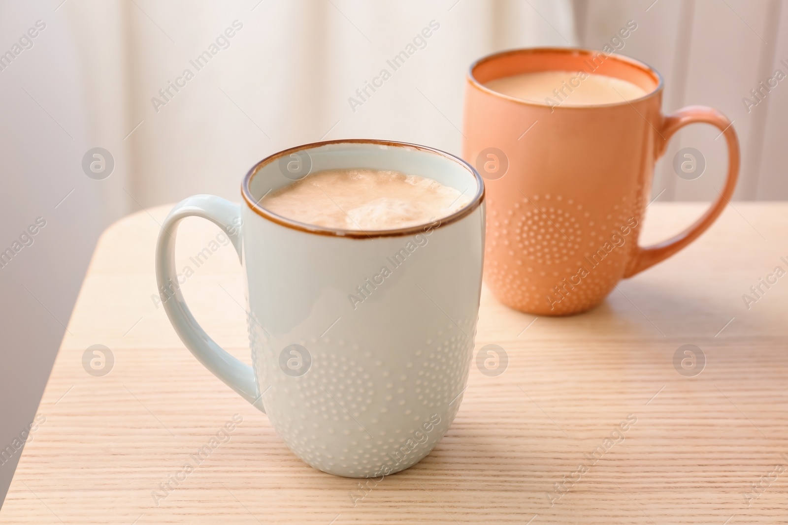 Photo of Cups of aromatic hot coffee on wooden table
