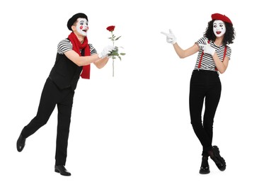 Happy mime giving rose to his girlfriend on white background