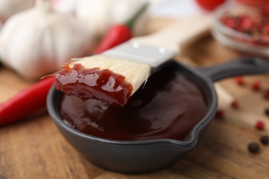 Marinade in gravy boat and basting brush on table, closeup