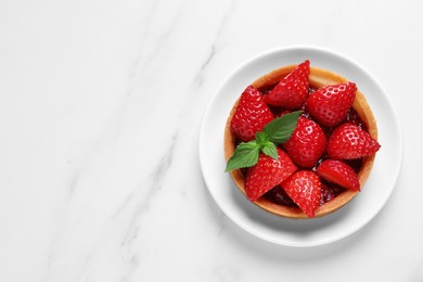 Photo of Tartlet with fresh strawberries on white marble table, top view and space for text. Delicious dessert