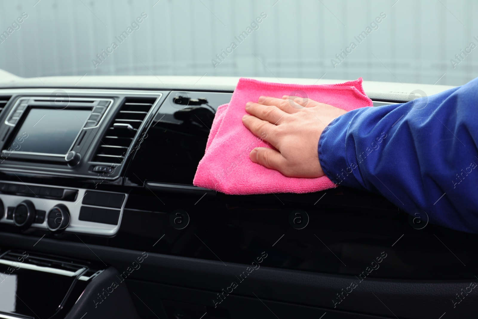 Photo of Car wash worker cleaning automobile interior, closeup