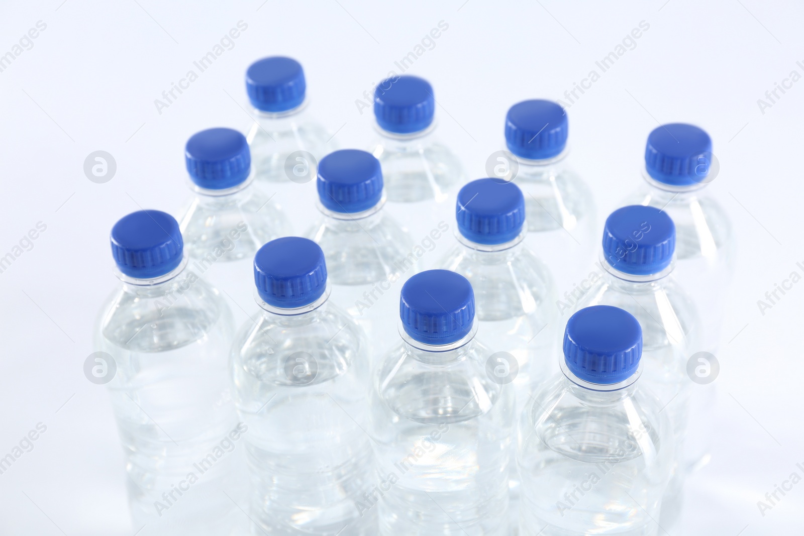 Photo of Plastic bottles with pure water on white background, closeup