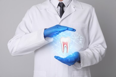 Dentist showing virtual model of tooth on light grey background, closeup