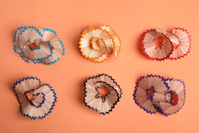 Pencil shavings on orange background, top view