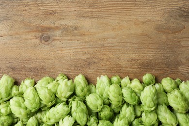 Photo of Fresh green hops on wooden table, top view. Space for text