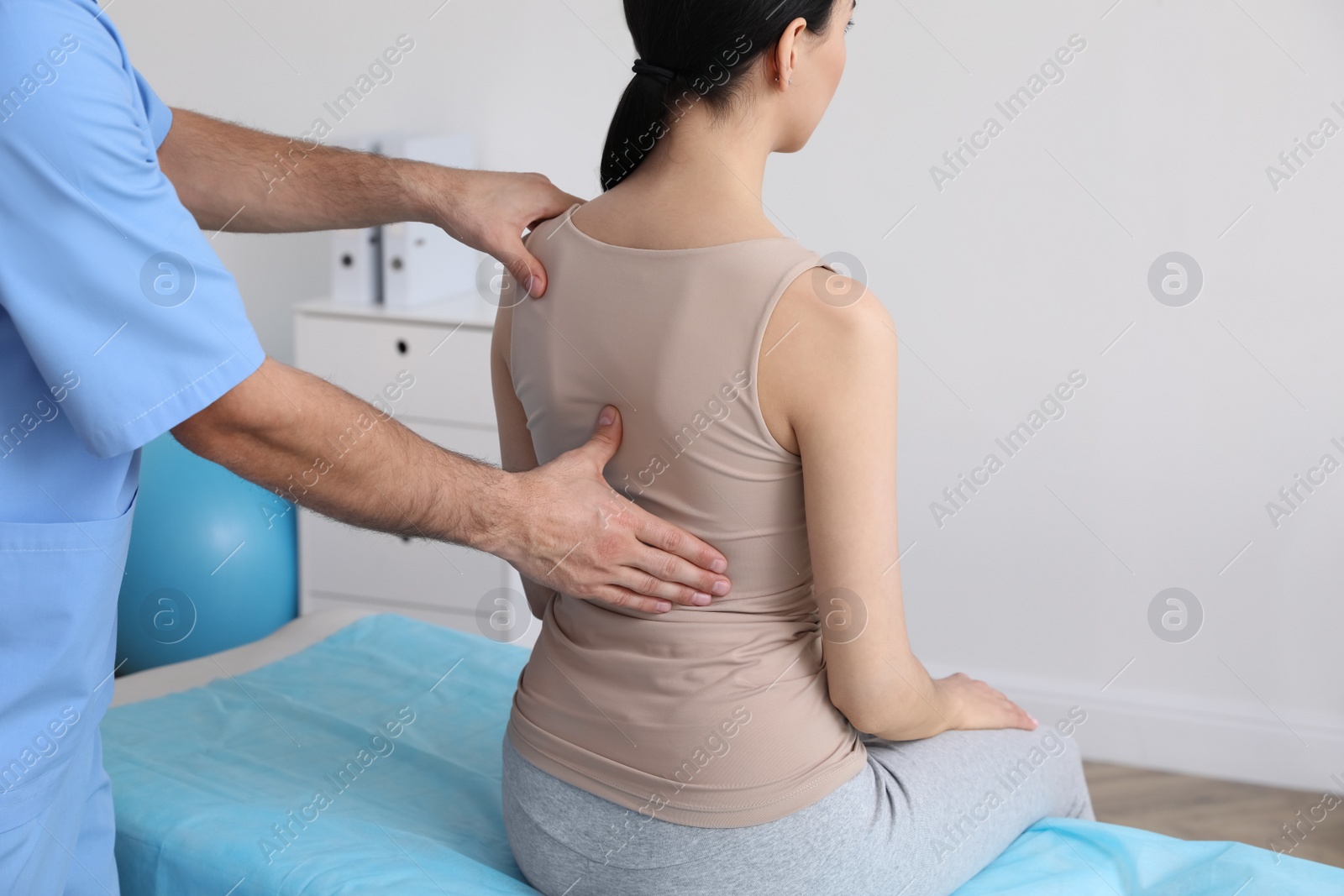 Photo of Orthopedist examining woman's back in clinic, closeup. Scoliosis treatment