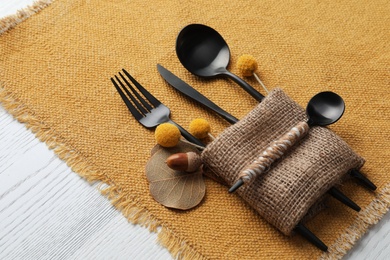 Photo of Autumn place setting with cutlery on white table, closeup