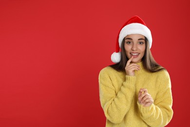 Photo of Happy woman in Santa hat on red background, space for text. Christmas countdown