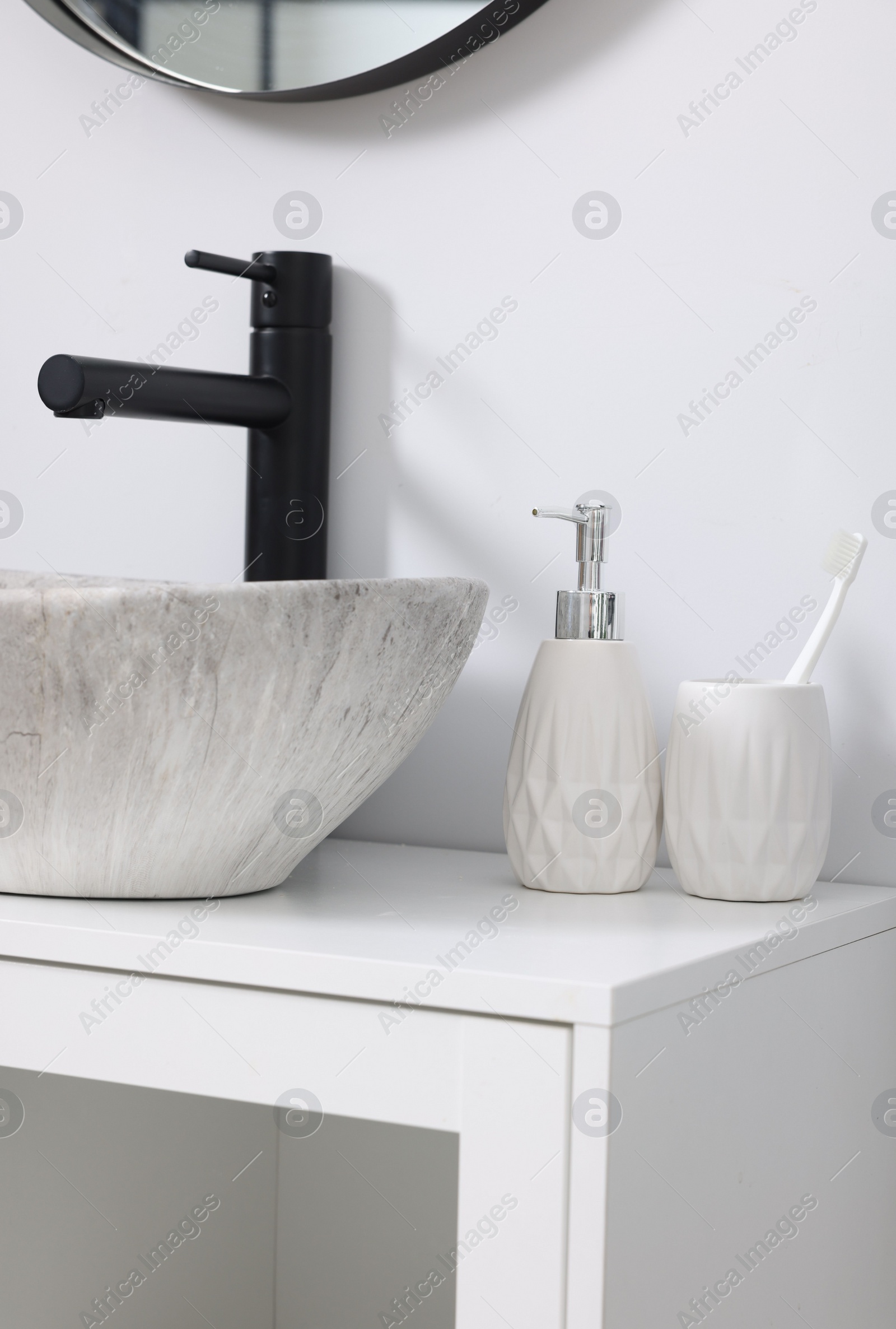 Photo of Different bath accessories and personal care products near sink on bathroom vanity