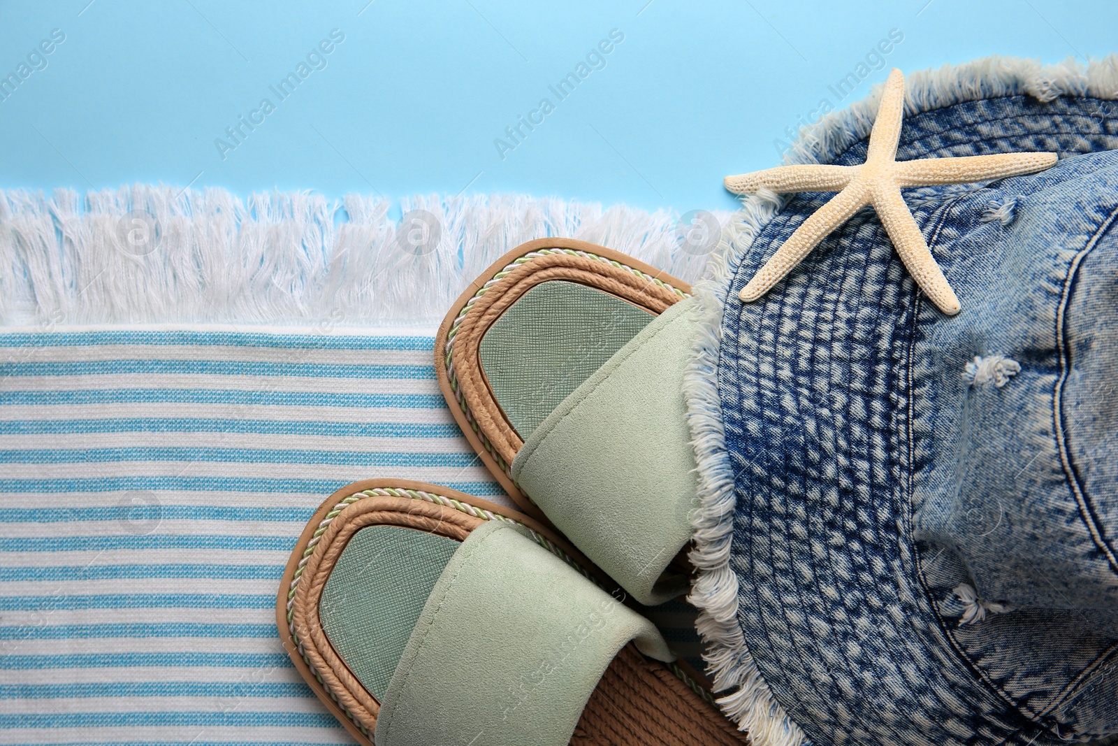 Photo of Flat lay composition with beach accessories on light blue background, space for text