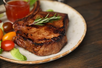 Photo of Tasty marinated meat, rosemary and tomatoes on wooden table, closeup
