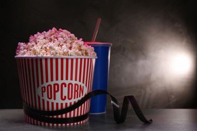 Photo of Delicious popcorn, drink and tape on table. Space for text