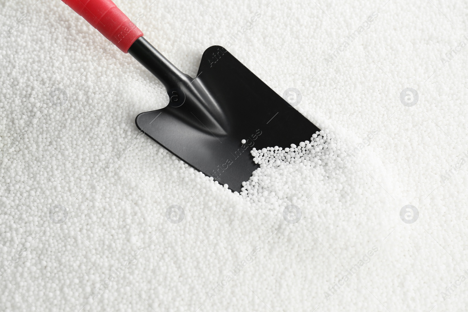 Photo of Shovel and granular mineral fertilizer, closeup view