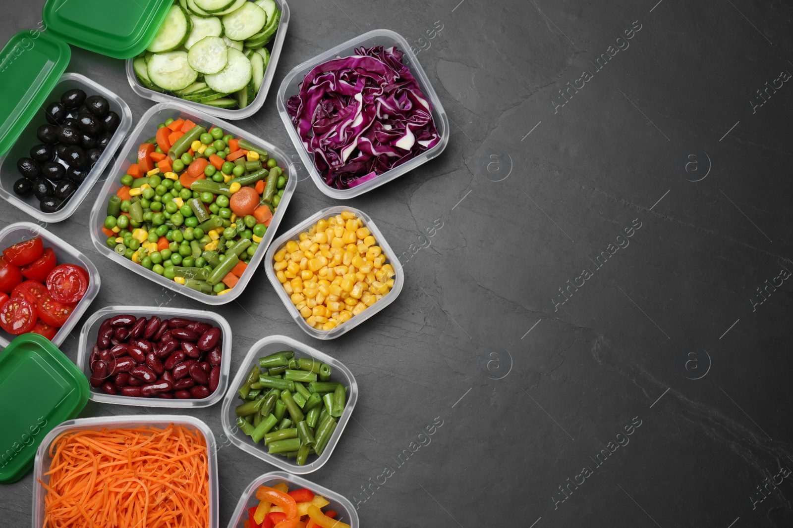 Photo of Set of plastic containers with fresh food on black table, flat lay. Space for text