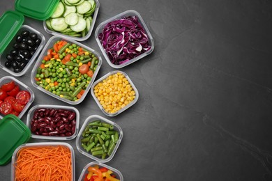 Photo of Set of plastic containers with fresh food on black table, flat lay. Space for text