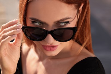 Photo of Beautiful woman in sunglasses outdoors on sunny day, closeup