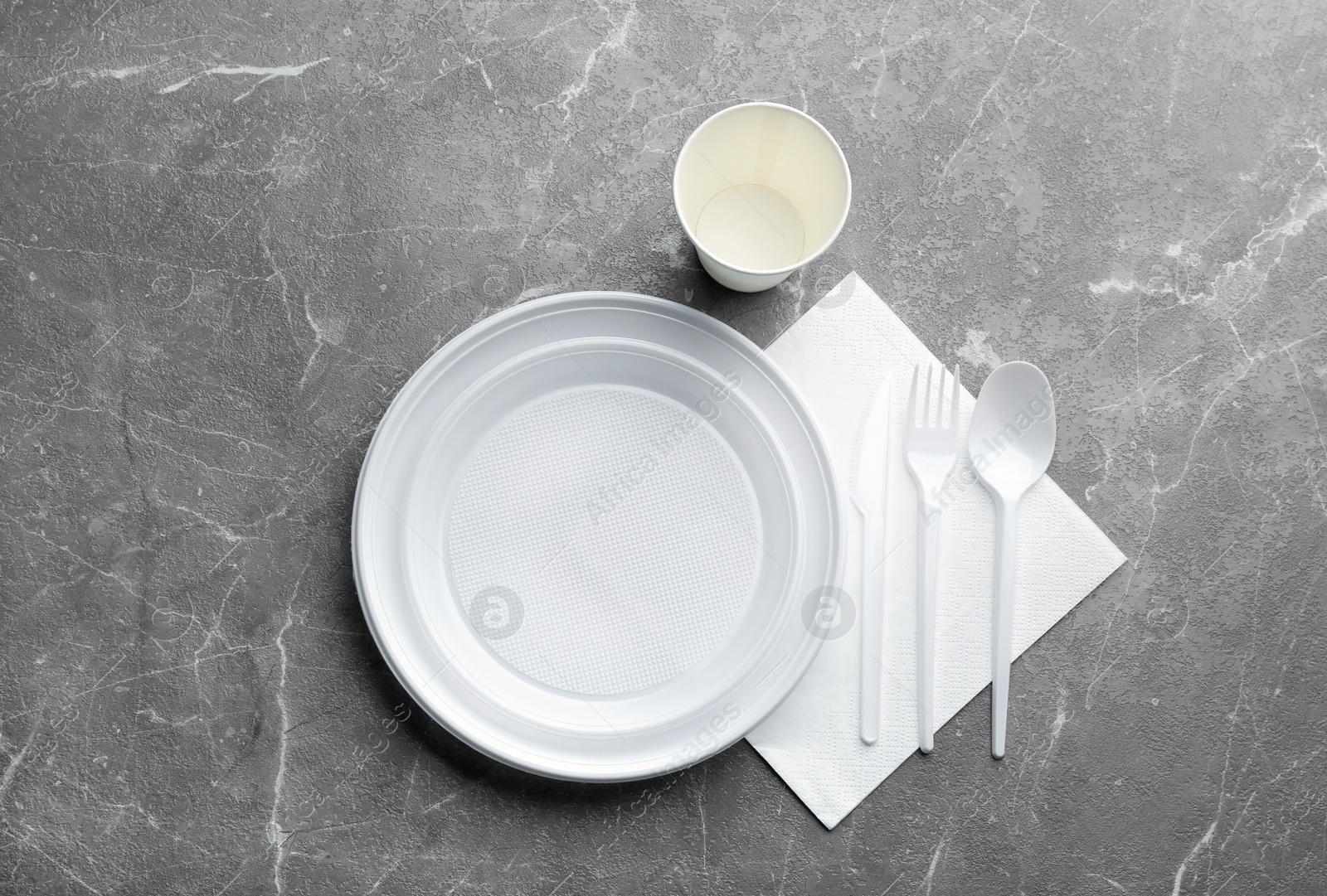 Photo of Composition with plastic dishware on grey background, flat lay. Picnic table setting