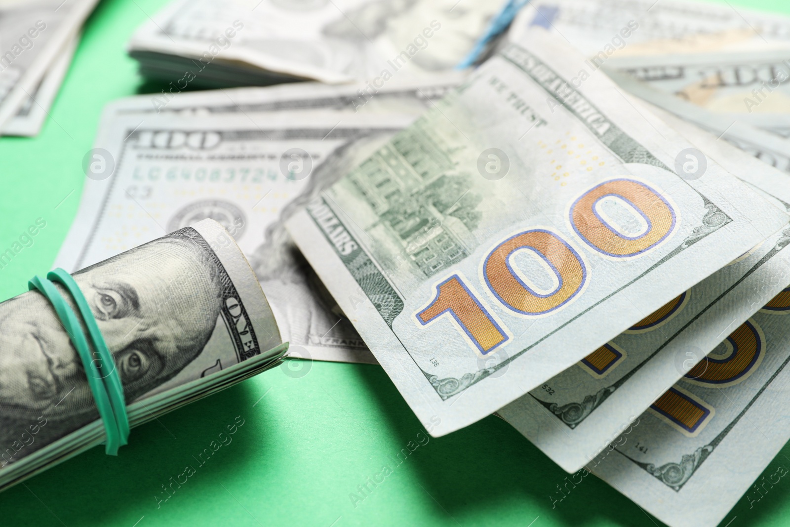 Photo of Many dollar banknotes on green background, closeup