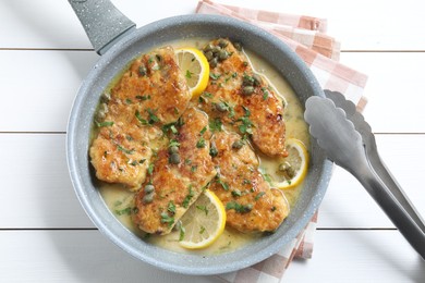 Photo of Delicious chicken piccata on white wooden table, top view