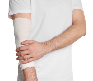 Man with arm wrapped in medical bandage on white background, closeup