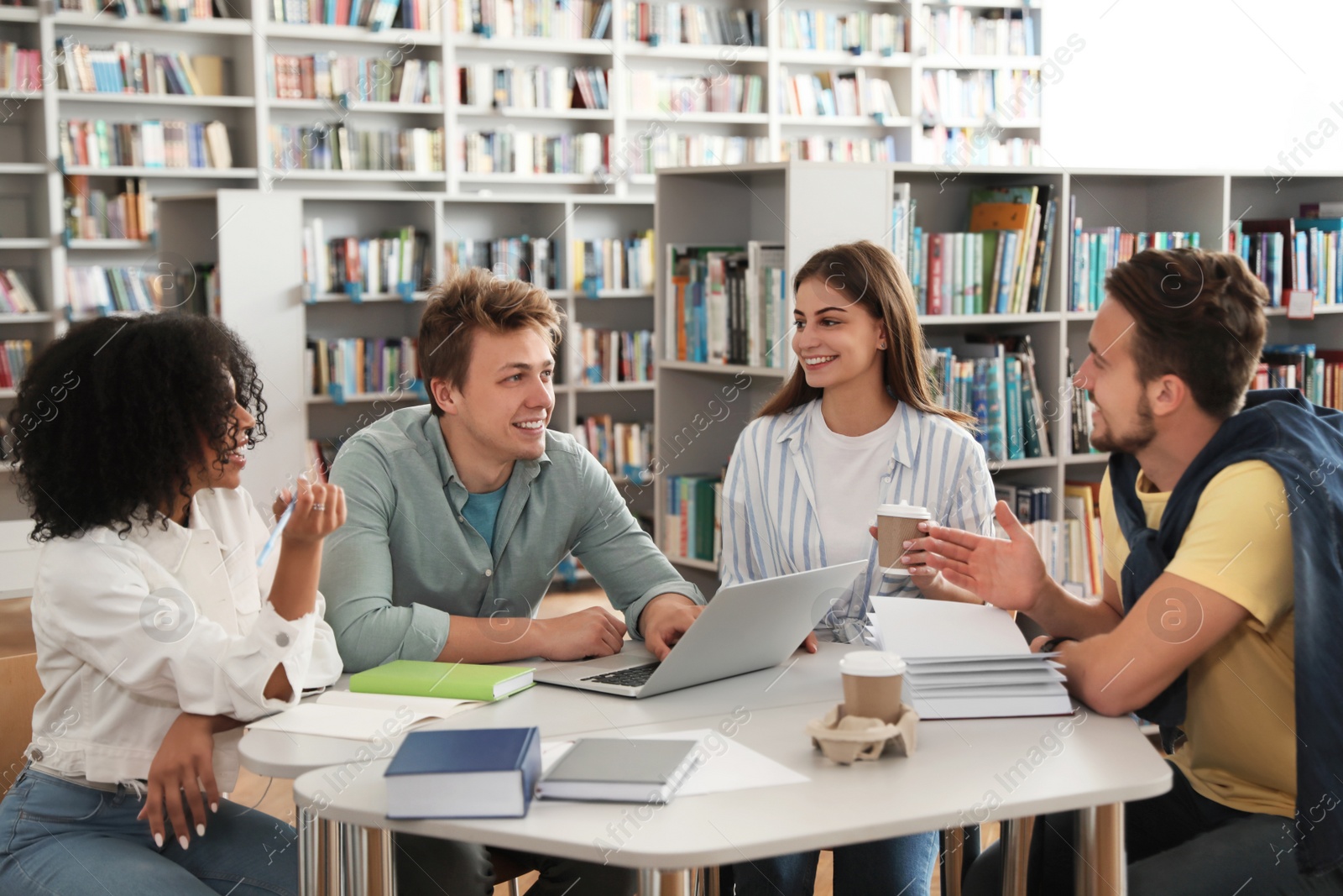 Photo of Group of young people studying at table in library