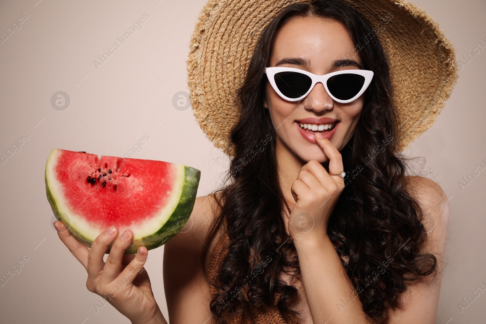 Photo of Beautiful young woman with watermelon on beige background