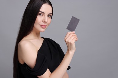 Photo of Woman holding blank business card on grey background. Space for text