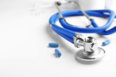 Photo of Stethoscope and pills on light background, closeup. Medical equipment