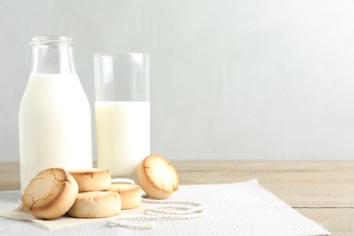 Photo of Tasty homemade cookies and milk on wooden table. Space for text