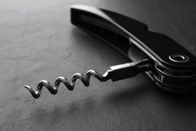 One corkscrew (sommelier knife) on grey textured table, closeup