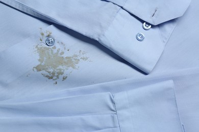 Closeup view of light blue shirt with stain