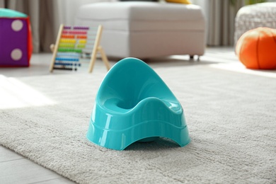 Modern blue potty on floor in nursery room. Toilet training