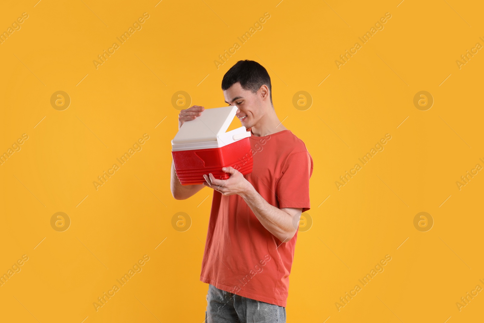 Photo of Man with red cool box on orange background