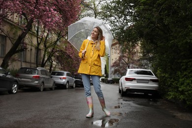 Young woman with umbrella walking on spring day