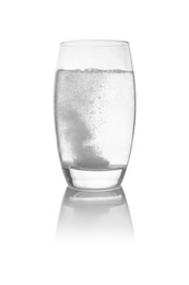 Effervescent pill dissolving in glass of water isolated on white