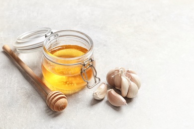 Jar with honey and garlic as cold remedies on table