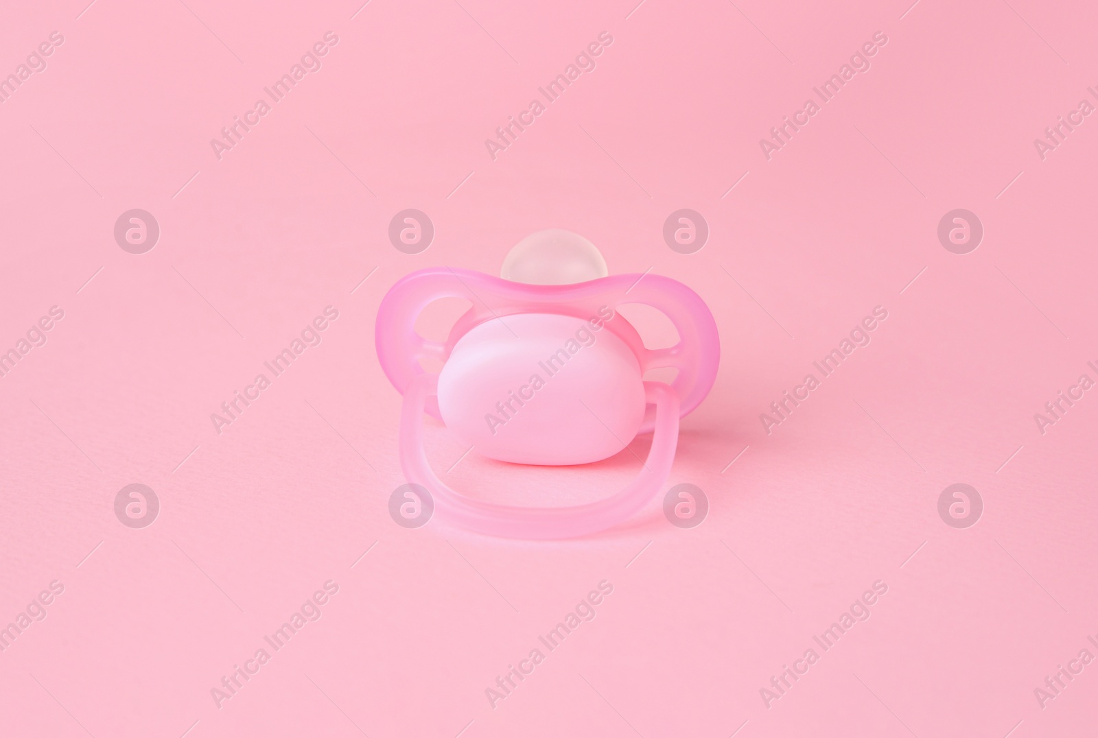 Photo of One new baby pacifier on pink background