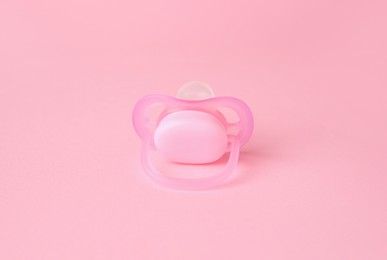 One new baby pacifier on pink background
