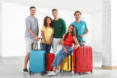 Photo of Group of young people with suitcases in light room