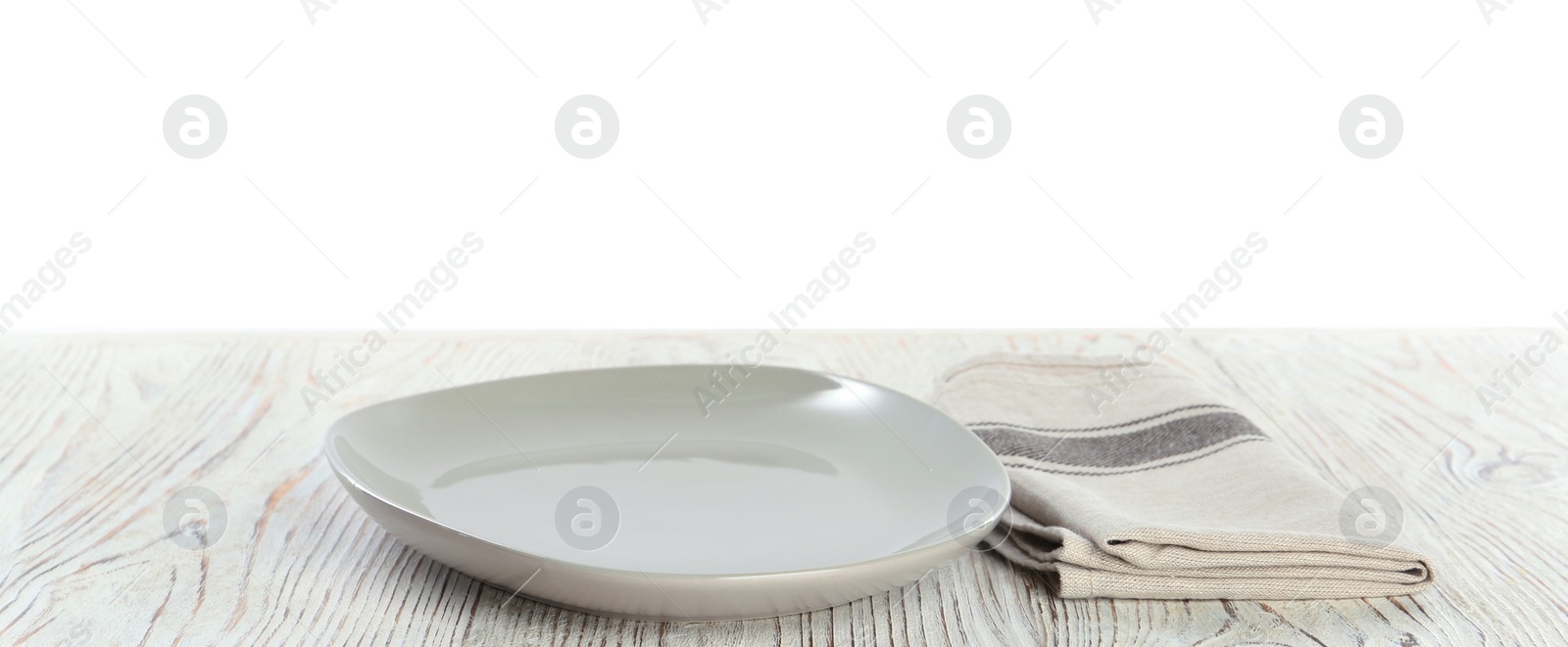 Photo of Empty plate and napkin on white wooden table