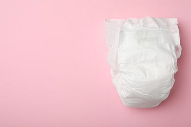 Photo of Baby diaper on pink background, top view. Space for text