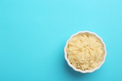 Bowl with tasty mashed potatoes and space for text on color background, top view