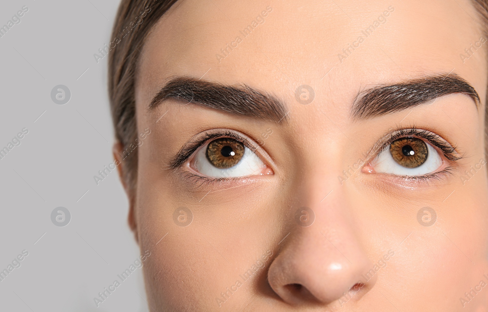 Photo of Beautiful woman with perfect eyebrows on light background