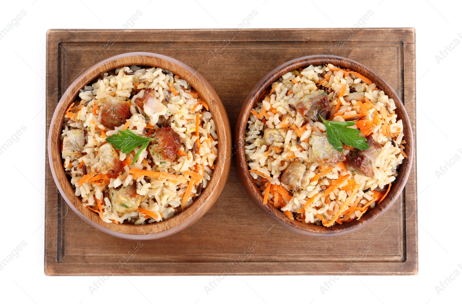 Photo of Delicious pilaf with meat and carrot in bowls isolated on white, top view