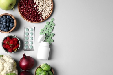 Photo of Many prebiotic pills and food on grey background, flat lay. Space for text