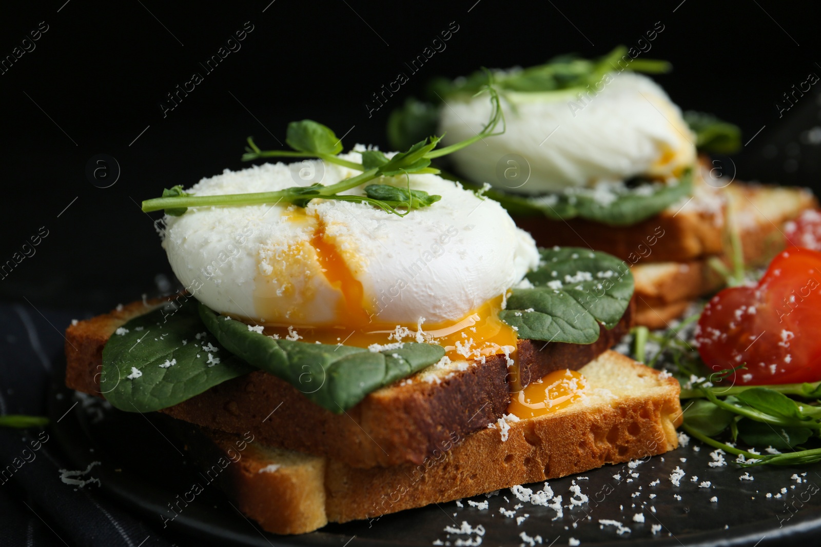 Photo of Delicious poached egg sandwich served on slate board, closeup