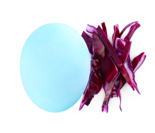 Light blue Easter egg painted with natural dye and red shredded cabbage on white background, top view