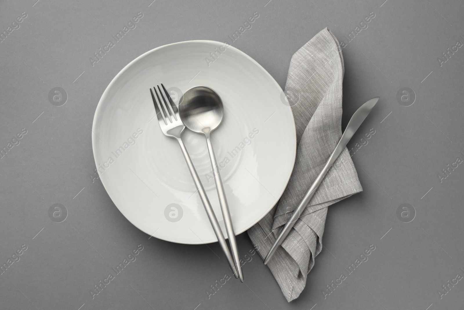Photo of Clean bowl and cutlery on grey background, top view