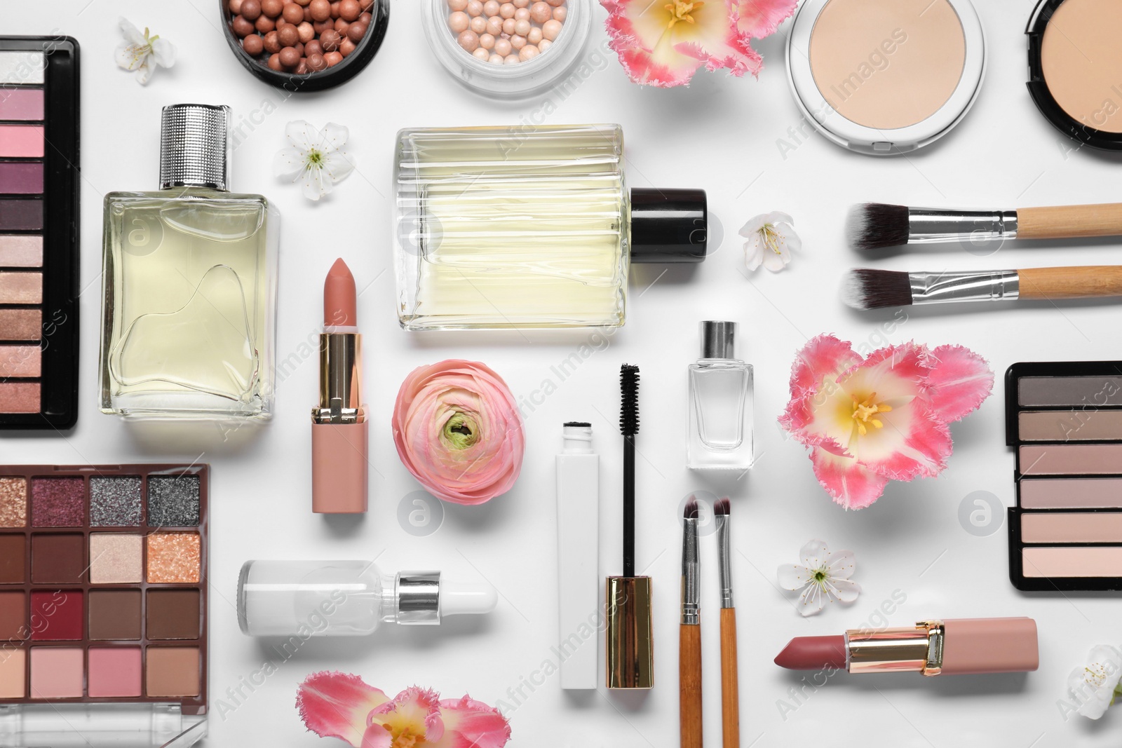 Photo of Flat lay composition with different makeup products and beautiful spring flowers on white background