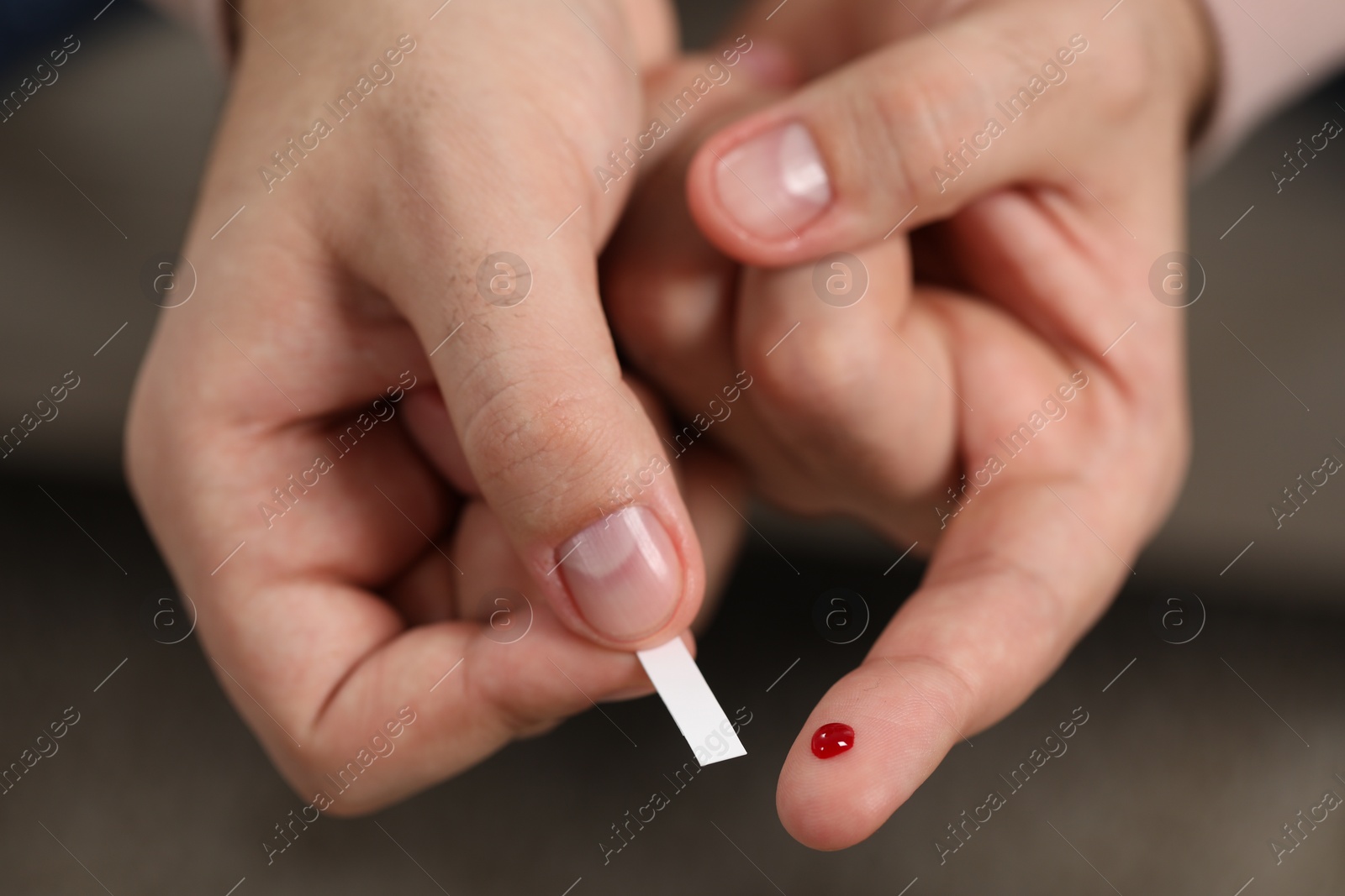 Photo of Diabetes test. Man checking blood sugar level with glucometer on blurred background, closeup